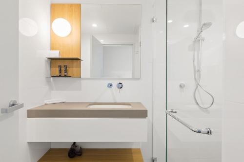 a bathroom with a shower, sink, and toilet at Mantra Hotel at Sydney Airport in Sydney