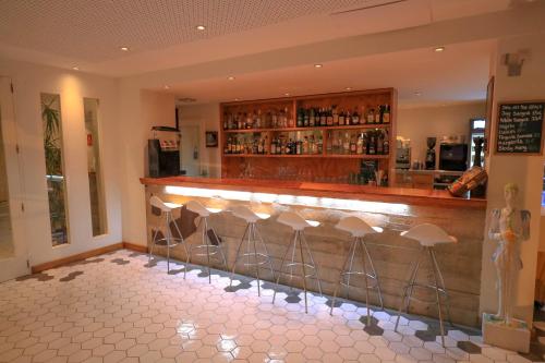 a bar with a row of stools in a room at Es Mitjorn in San Antonio