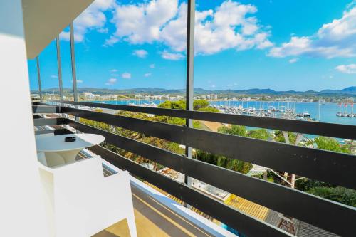 a balcony with a view of a harbor at Es Mitjorn Hotel in San Antonio