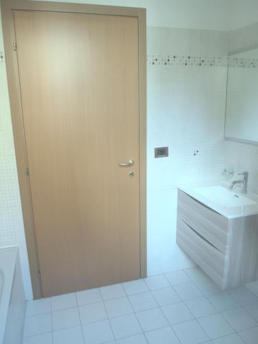 a bathroom with a wooden door and a sink at Casa Vacanze Marone in Marone