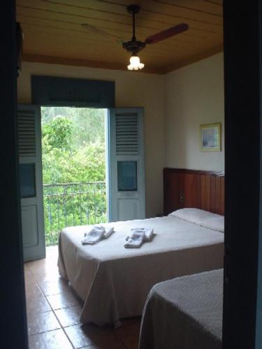 a bedroom with a bed with towels on it at Pousada do Canto in Rio Acima