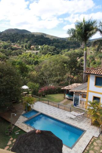 a swimming pool in front of a house at Pousada do Canto in Rio Acima