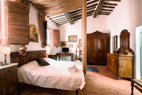 a bedroom with a large bed and wooden furniture at Antiche Dimore Vescovado in Murlo