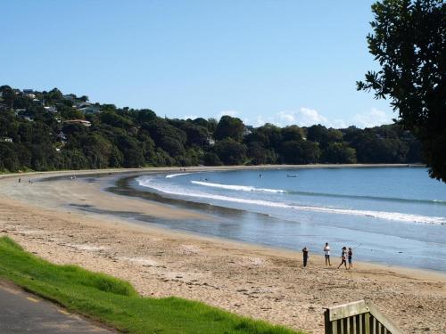 a group of people walking on a beach at Jake's Place Oneroa Waiheke in Oneroa
