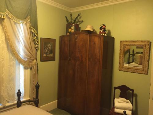 a bedroom with a wooden cabinet and a bed at The Whitmore Inn in Weaverville