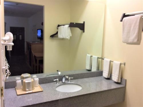 a bathroom with a sink and a mirror at Texas Inn - Welasco/Mercedes in Weslaco
