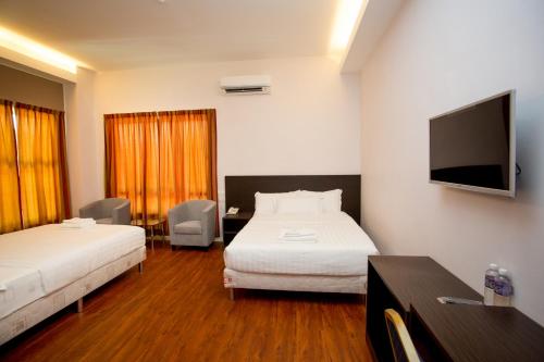 Labuan Fortune Hotel في لابوان: غرفة فندقية بسريرين وتلفزيون بشاشة مسطحة