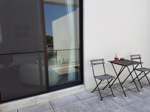 two chairs and a table on a balcony at Tainan Anping - Shuiau 180 in Tainan