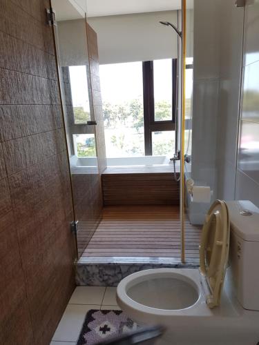 a bathroom with a toilet and a shower with a window at Tainan Anping - Shuiau 180 in Tainan