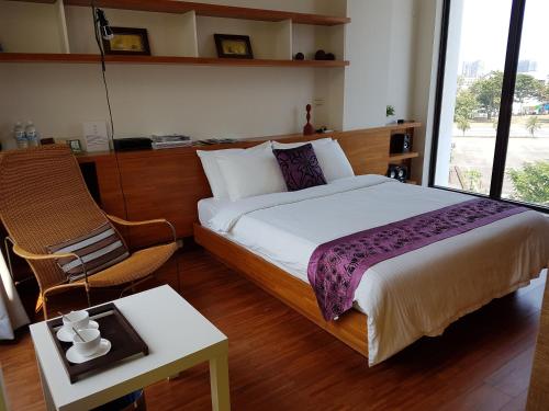 a bedroom with a bed and a chair and a table at Tainan Anping - Shuiau 180 in Tainan