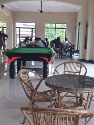 a group of people sitting around a pool table at Blue Diamond Hostel in Battambang
