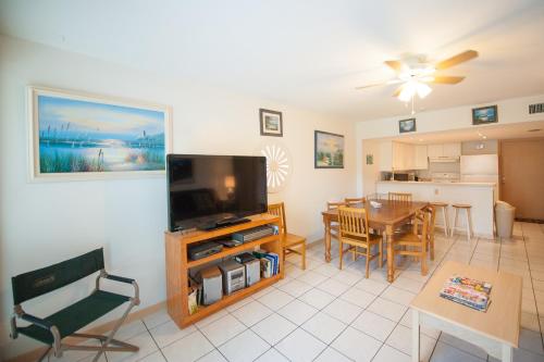 a living room with a television and a dining room at South Padre Island Beach Rentals in South Padre Island