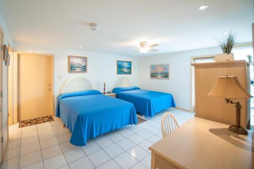 a hotel room with two beds and a table at South Padre Island Beach Rentals in South Padre Island