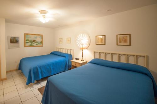um quarto com duas camas e um candeeiro sobre uma mesa em South Padre Island Beach Rentals em South Padre Island
