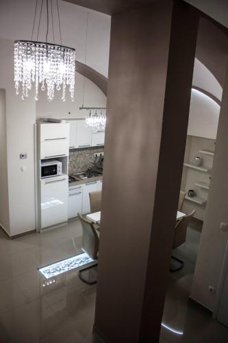 a kitchen with white cabinets and a chandelier at Melior Szálló in Eger