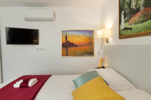 a bedroom with a bed and a tv on the wall at Art & Wine Boutique Hotel in Larnaka