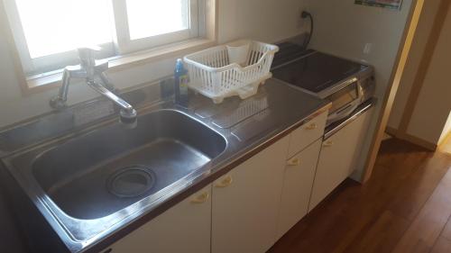 a kitchen sink with a faucet and a dishwasher at Ocean Front Miyakojima in Miyako Island