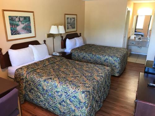 a hotel room with two beds and a sink at Motor Inns Of America in Madisonville