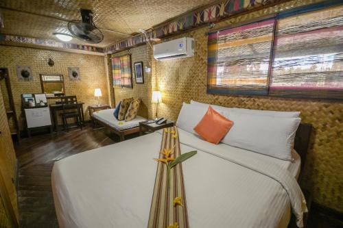 ein Schlafzimmer mit einem Bett und einem Sofa in einem Zimmer in der Unterkunft Puerto Pension Inn in Puerto Princesa