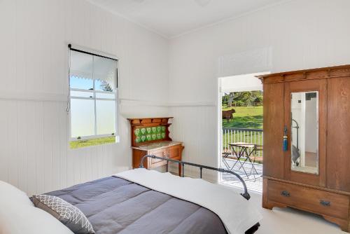 sypialnia z łóżkiem, komodą i oknem w obiekcie Cloud Hill w mieście Maleny
