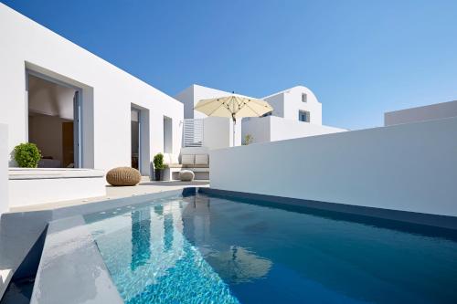 a swimming pool in front of a white house at Nova Luxury Suites in Pirgos