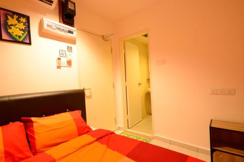 a bedroom with a bed with orange and orange sheets at Famosa 2 Stay in Melaka