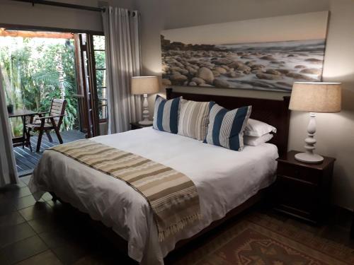 a bedroom with a bed with two lamps and a balcony at The Sandpiper in St Lucia