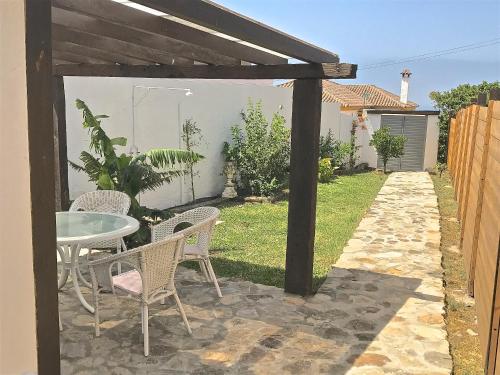 a patio with a table and chairs in a yard at Sol de Bolonia 5 in Bolonia