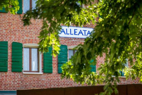 a sign on the side of a brick building with green shutters at Agriturismo Ca' Alleata in Caorle