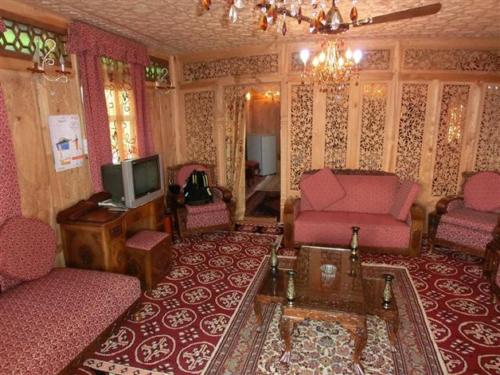 a living room with pink furniture and a tv at Chicago Group of Houseboats in Srinagar