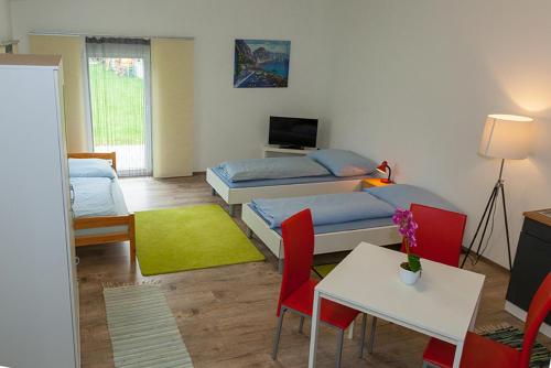 a living room with two beds and a table and chairs at Gästepension Sport 71 in Strasshof an der Nordbahn