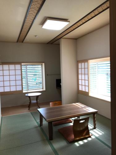 a room with a wooden table and windows at Ryokan Seifuso in Ōmuta