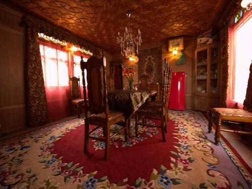 a dining room with a table and chairs on a red rug at Chicago Group of Houseboats in Srinagar