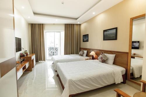 Cette chambre comprend deux lits et une télévision. dans l'établissement Halong Seoul Hotel, à Hạ Long