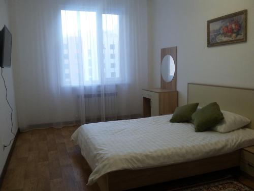 - une chambre avec un lit avec un miroir et une fenêtre dans l'établissement Apartment 115 Expo Boulevard, à Astana