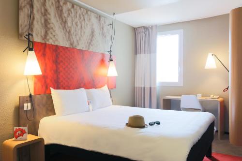 a hotel room with a bed with a hat on it at Ibis Albi in Albi