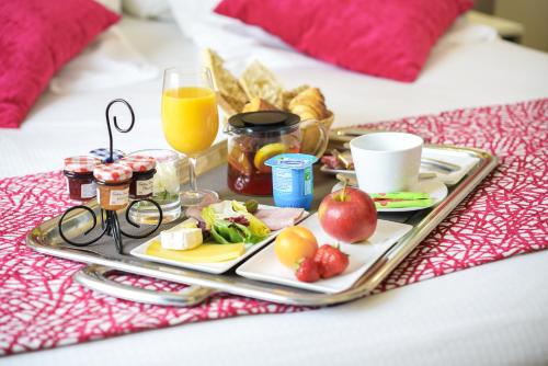 a tray of food on a bed with a breakfast at Hôtel Saphir Lyon in Lyon