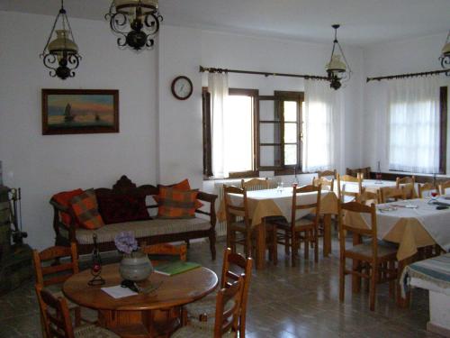a dining room with tables and chairs and a dining room with tablesktop at Hotel Tsagarada in Tsagarada