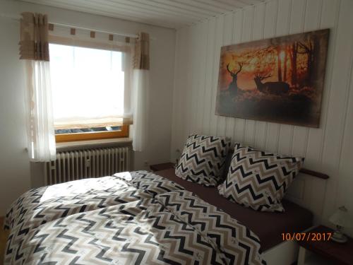 フリードリヒスハーフェンにあるFerienwohnung Desiréeのベッドルーム1室(ベッド1台付)が備わります。壁に絵が飾られています。