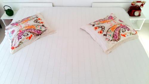 a white bed with two pillows on it at Apartments House of Art in Nin