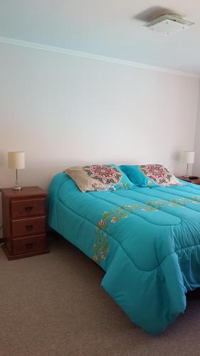 a bedroom with a blue bed and a night stand at Papudo Laguna in Papudo