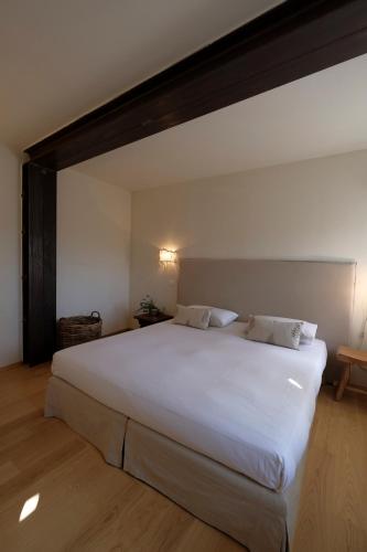 a bedroom with a large white bed in a room at Cortile nel borgo in Marina Palmense