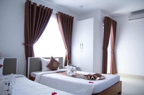 a bedroom with two beds and a window at Poetic Hue Hotel & Spa in Hue