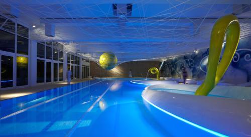 una piscina in un edificio con piscina illuminata di Park Hotel Ai Cappuccini a Gubbio