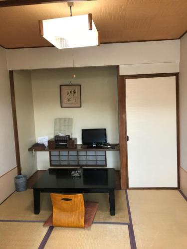 a living room with a table and a door at Ryokan Seifuso in Ōmuta