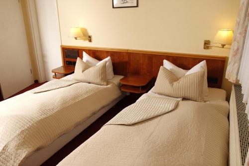 two beds in a hotel room with white pillows at Brocki's Hotel Stadt Hamburg in Parchim