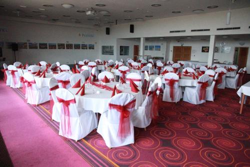 a room filled with white tables with red and white bows at PRIMAVERA Hotel & Congress centre in Plzeň