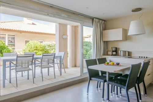 a kitchen and dining room with a table and chairs at Residence Cap Hermes - maeva Home in Fr&eacute;jus