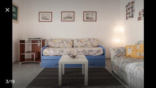 ガエータにあるCasa vacanze Serapoのリビングルーム(青いソファ、テーブル付)