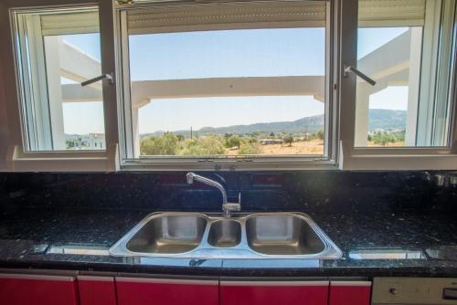 a sink in a kitchen with two windows at Villa Luca in Pastida